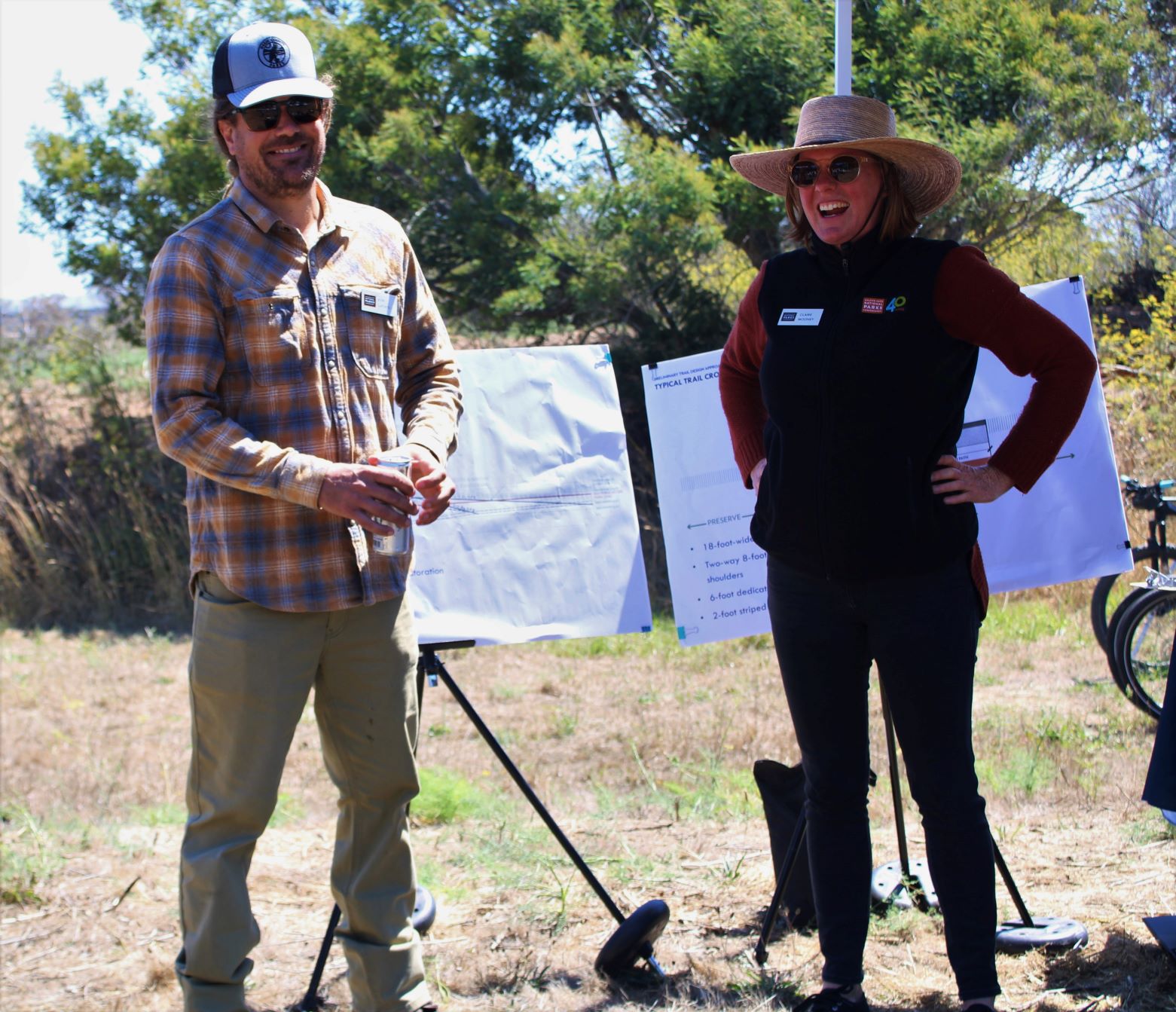 Two staff people are each standing in front of a presentation board with Bothin Marsh Preserve in the background. 